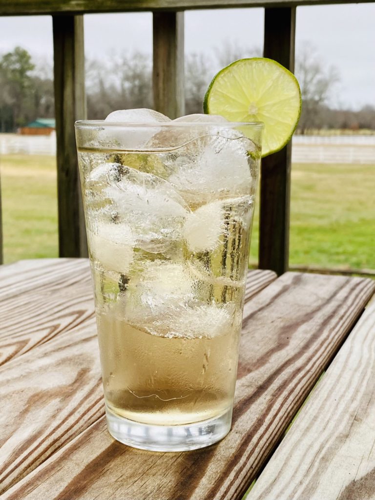 bay ginger ale cocktail with lemon slice on deck