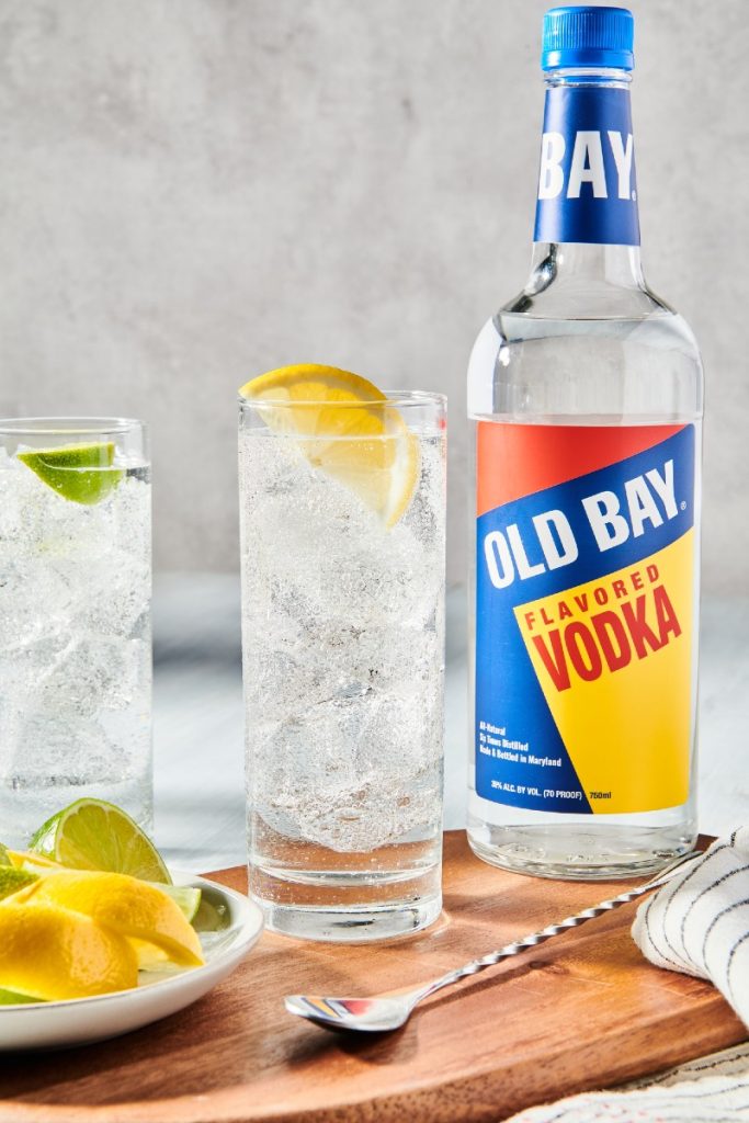 two cocktails with lemon lime and old bay vodka bottle