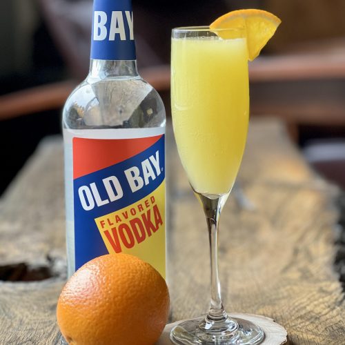 bellini cocktail with old bay vodka bottle and orange