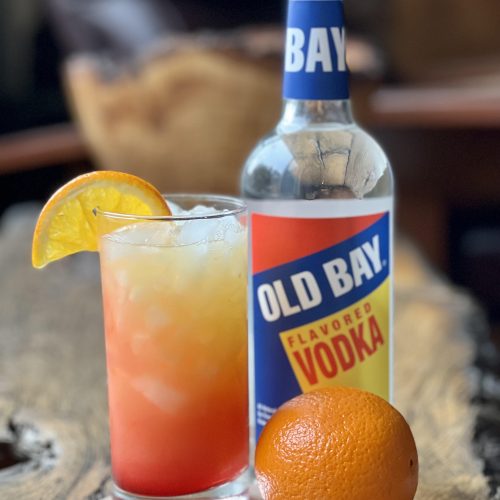 cocktail with old bay vodka bottle and orange