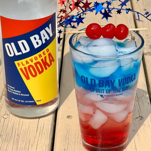 old bay vodka bottle with red white and blue cocktail with cherries